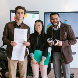 Diverse young entrepreneurs showcasing a new product prototype in a modern office.